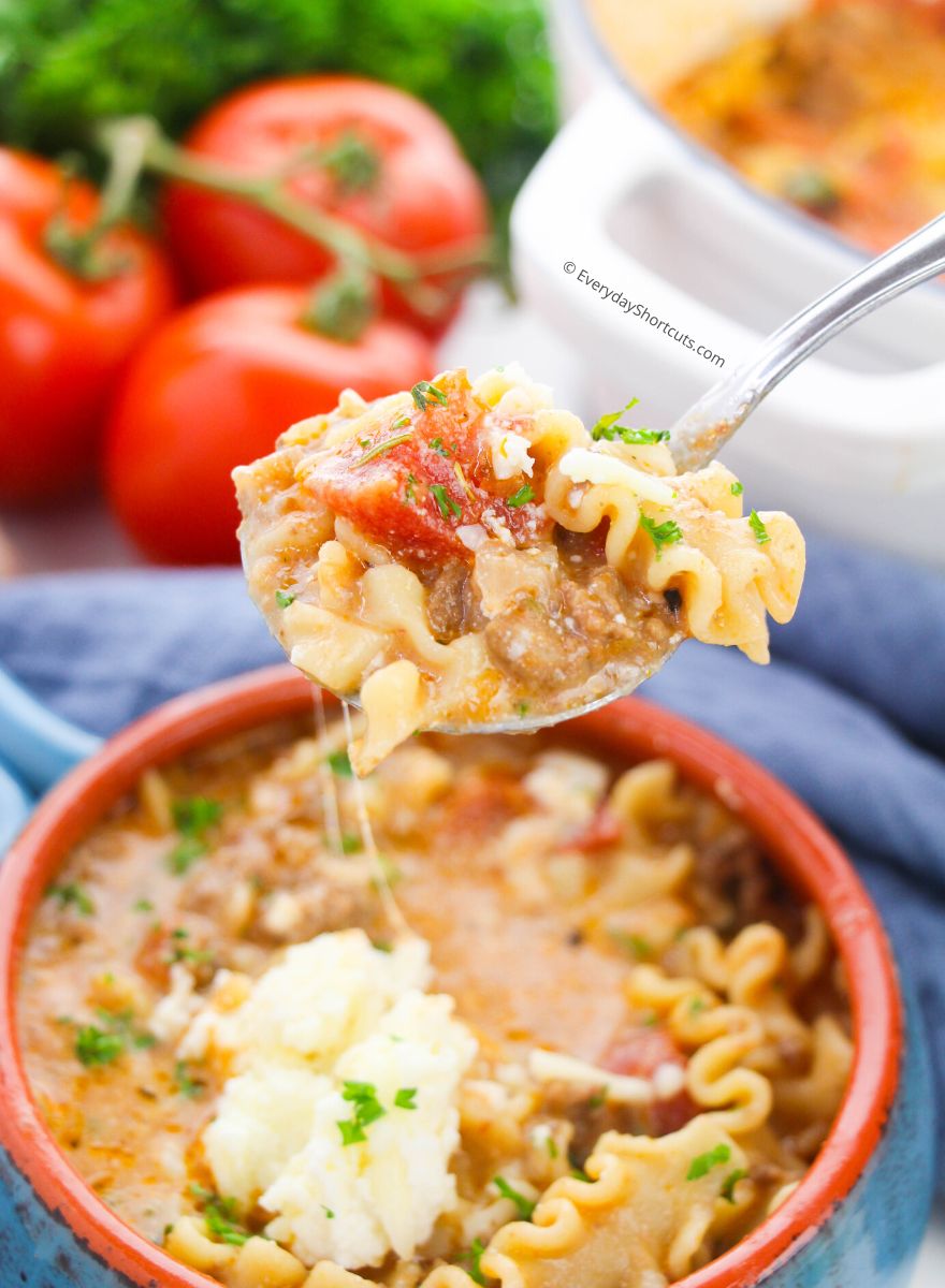 spoonful of lasagna soup with a cheese pull