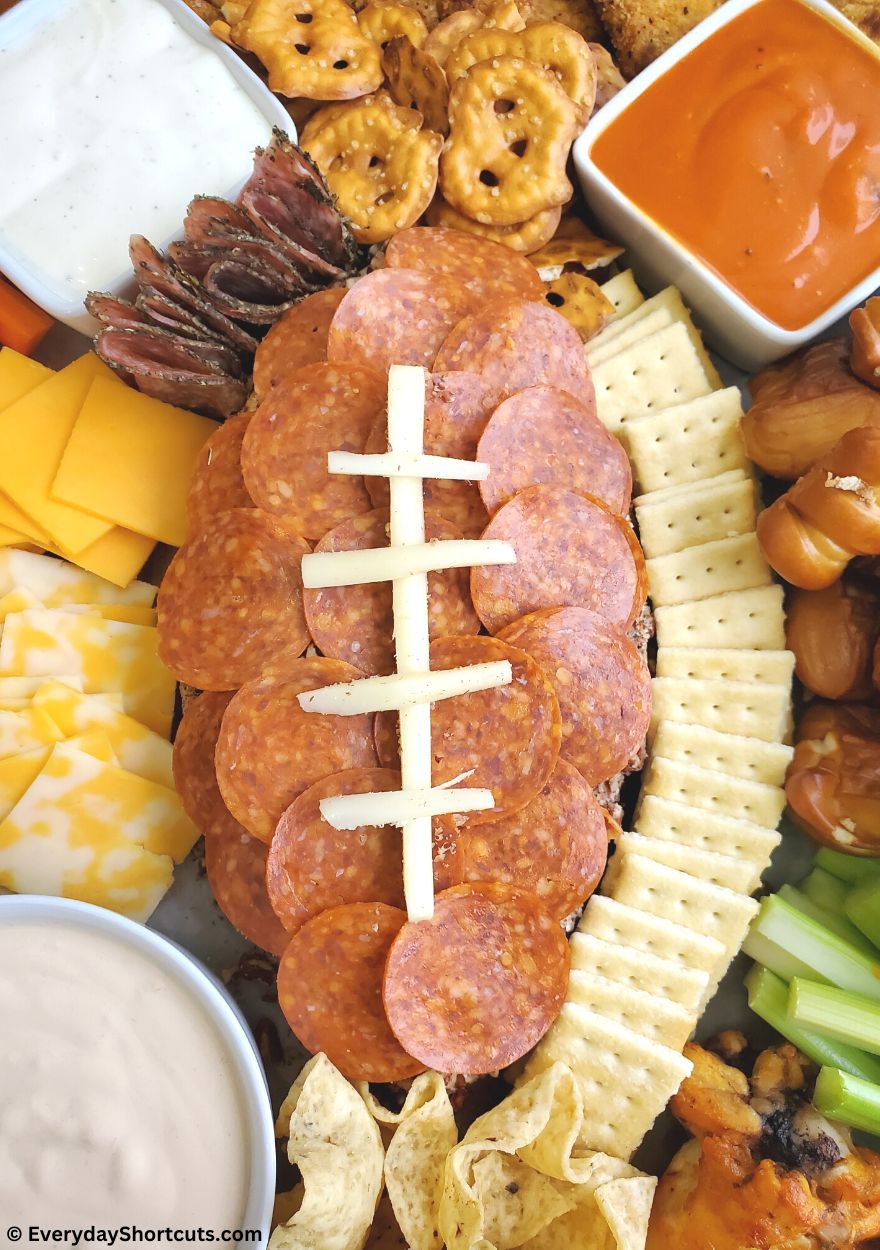Football shaped cheese ball on a platter