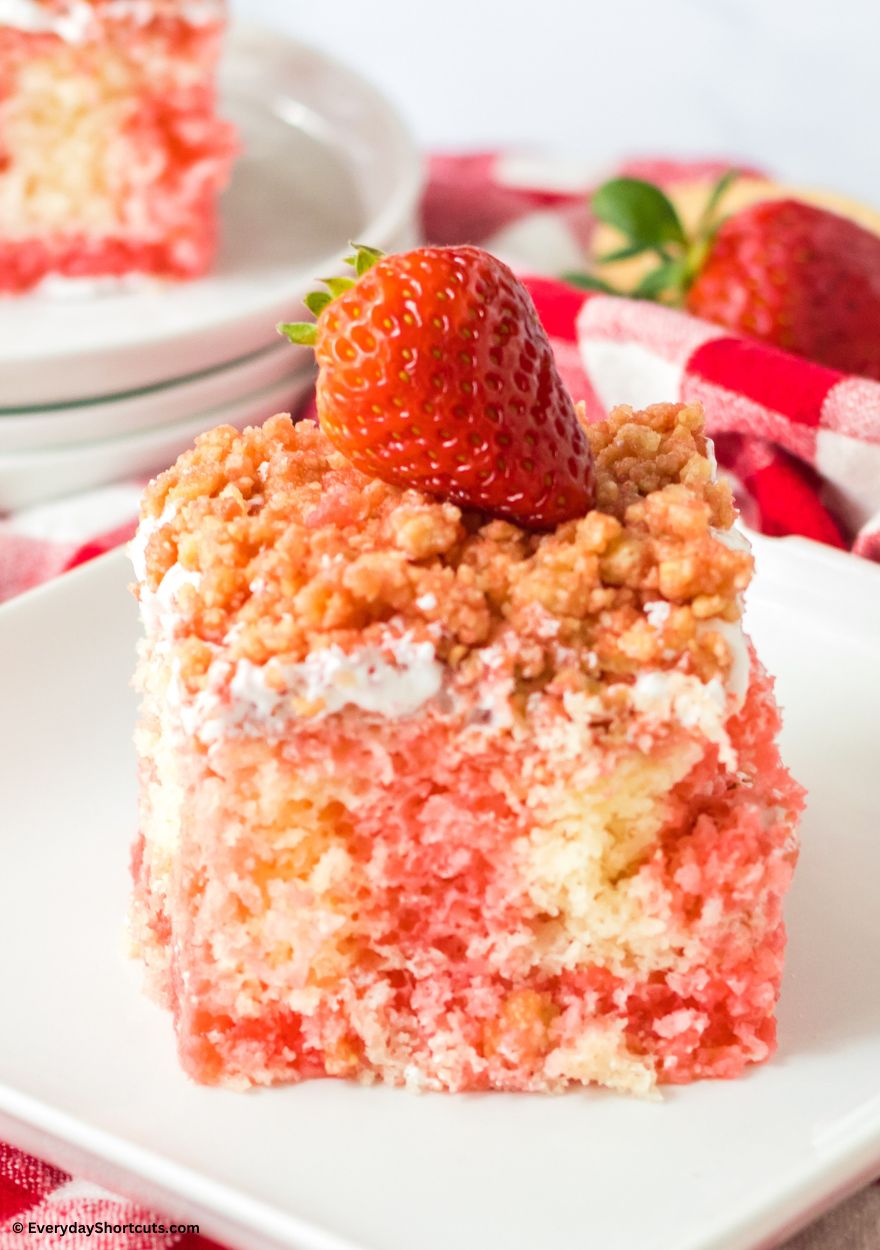 strawberry poke cake garnished with a strawberry