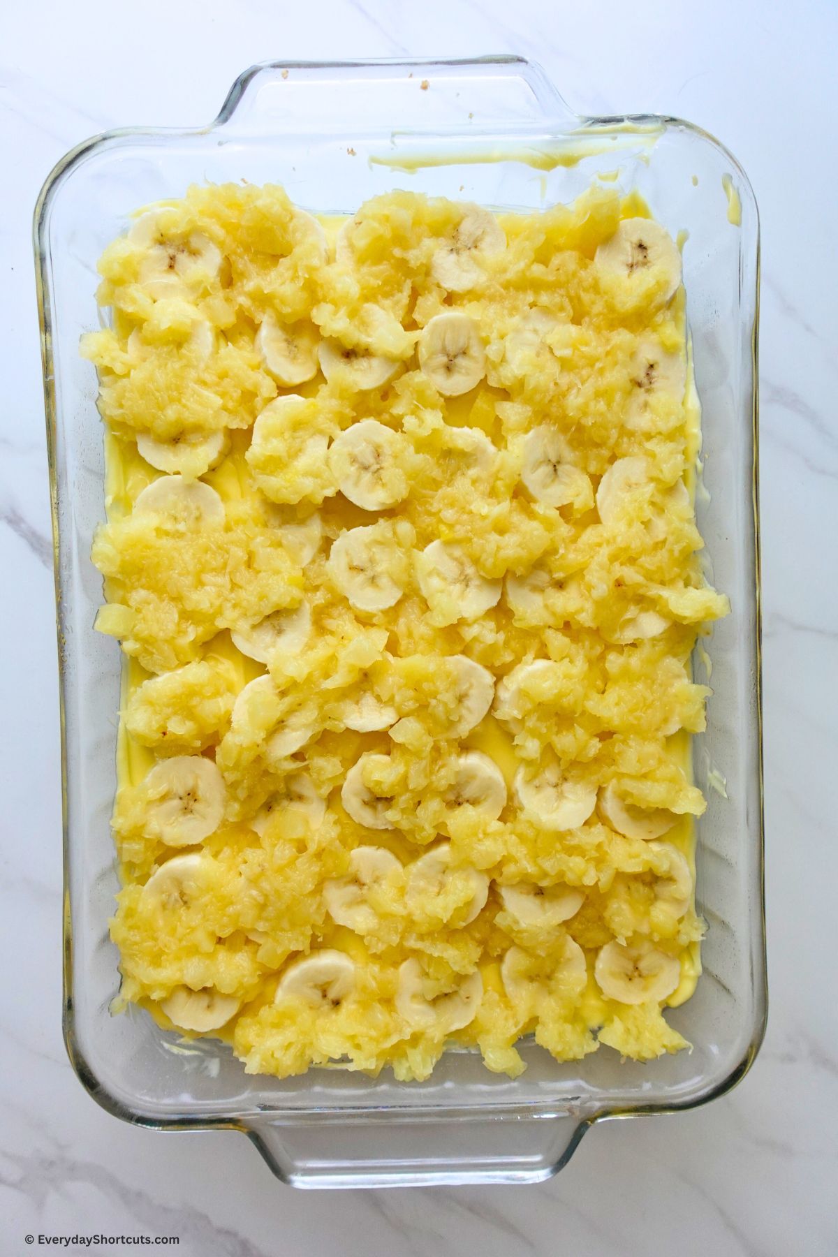 crushed pineapple on top of bananas in   baking dish