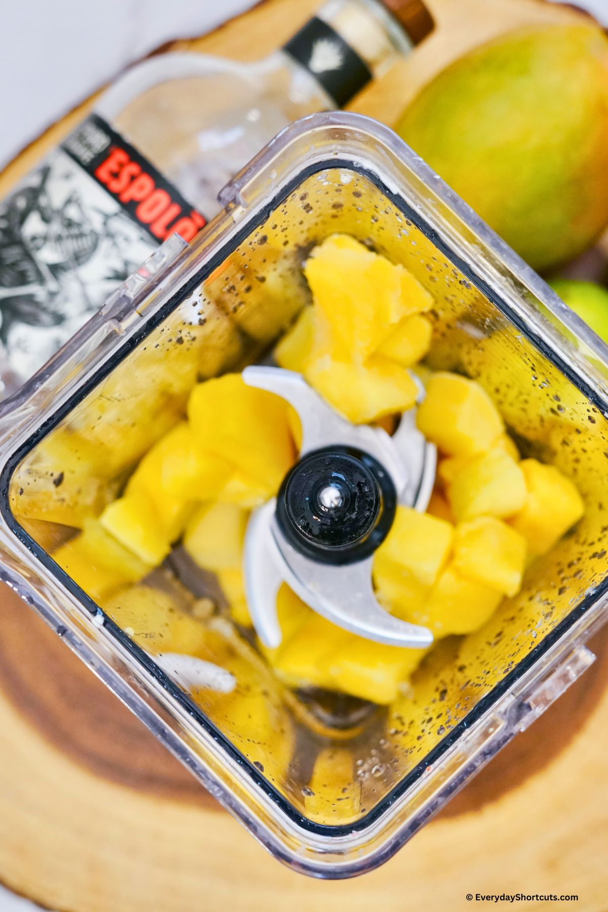 adding frozen mango to a blender