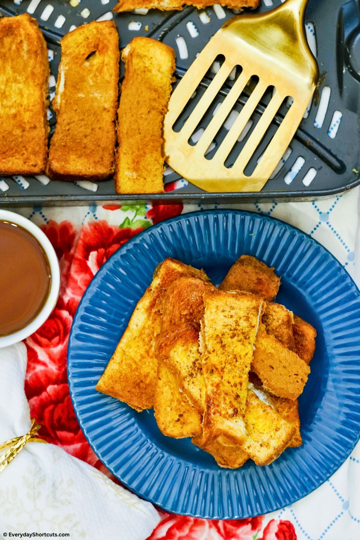 french toast sticks on a plate with air fryer basket next to it