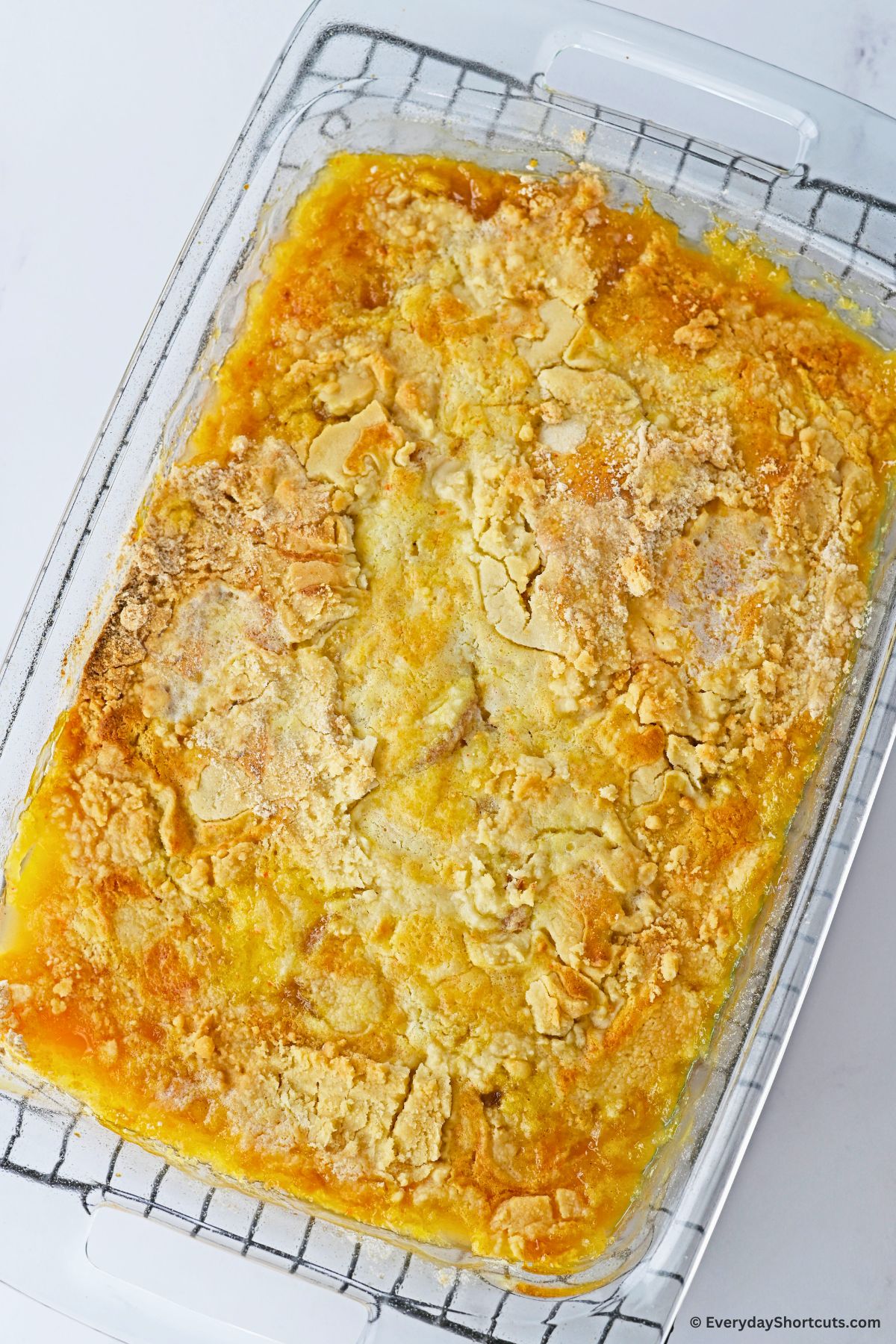 baked peach dump cake in a baking dish on a cooling rack