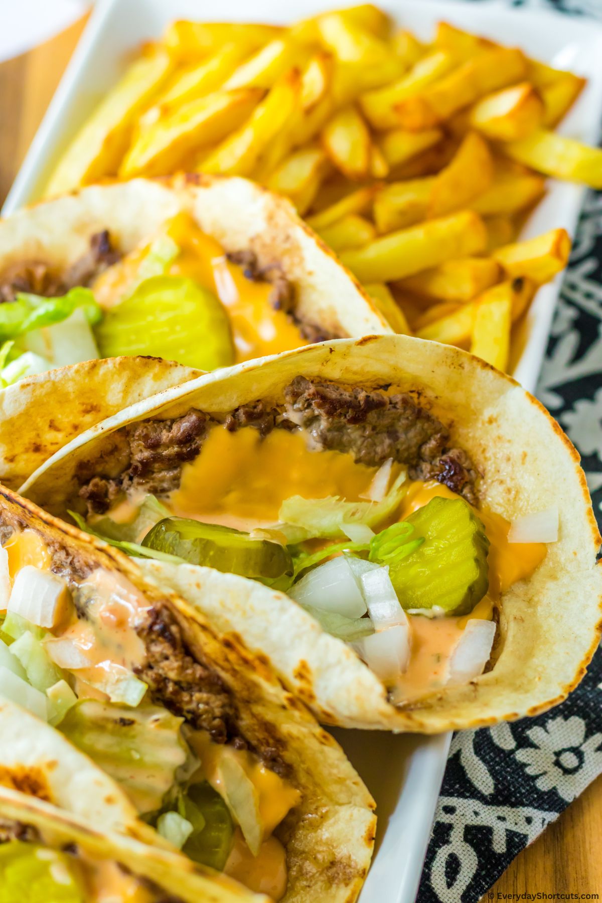 smash burger tacos on a platter with fries