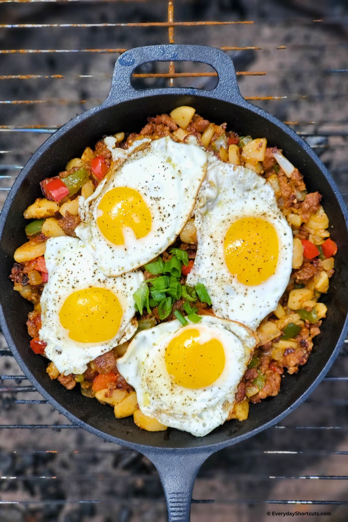 campfire breakfast hash with chorizo in a skillet on an open fire
