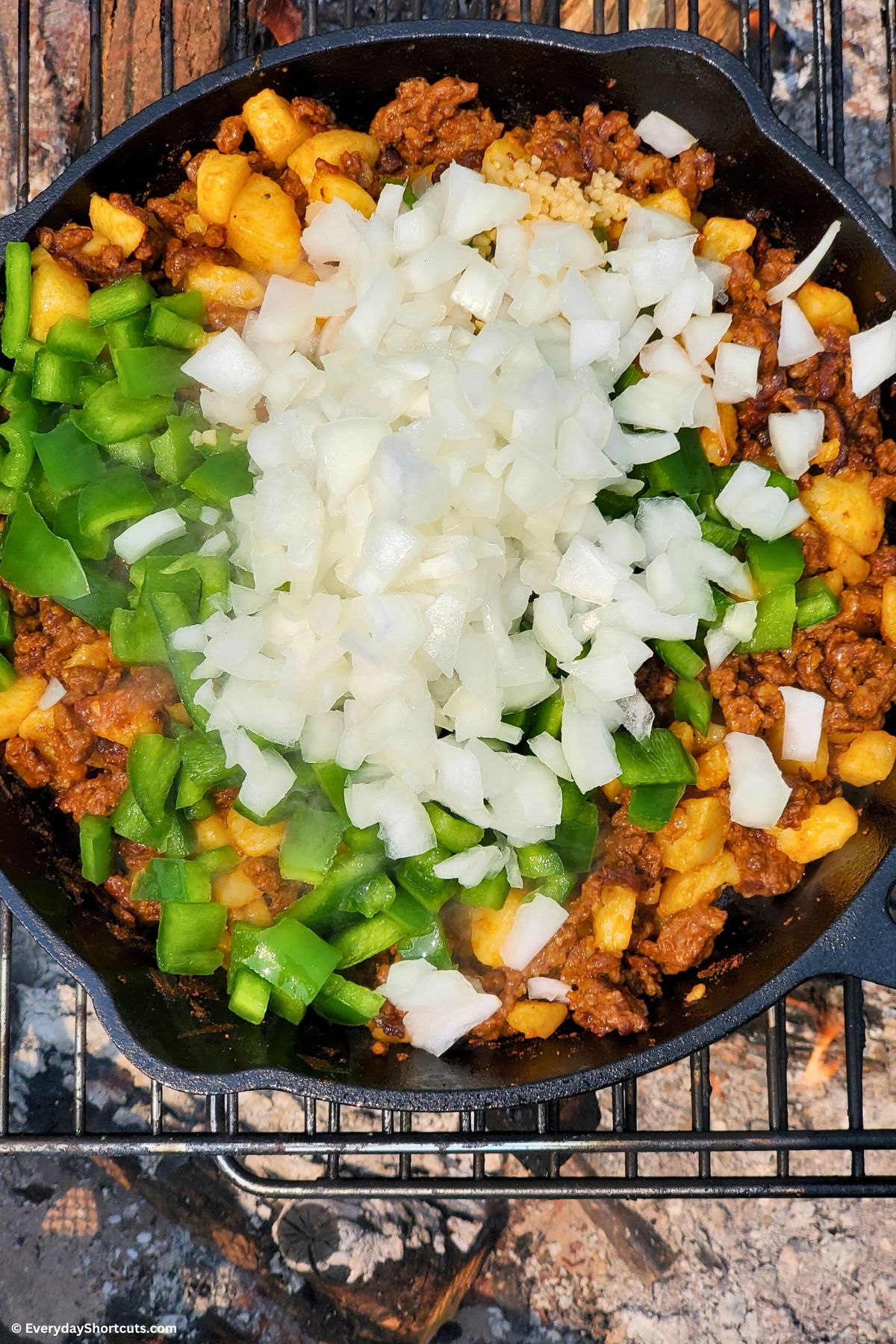 onions green peppers chorizo and potatoes in a skillet