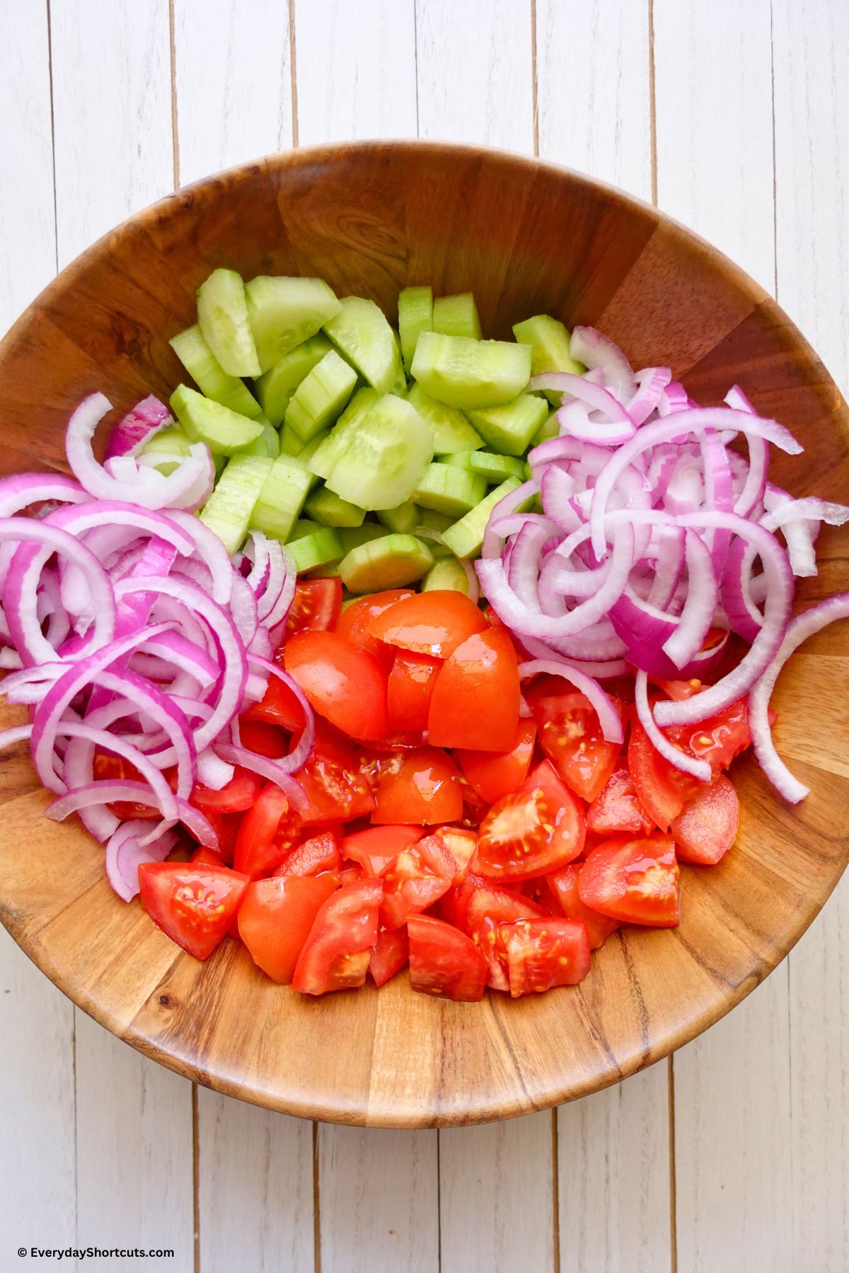 cut up tomatoes cucumbers and onions in a bowl