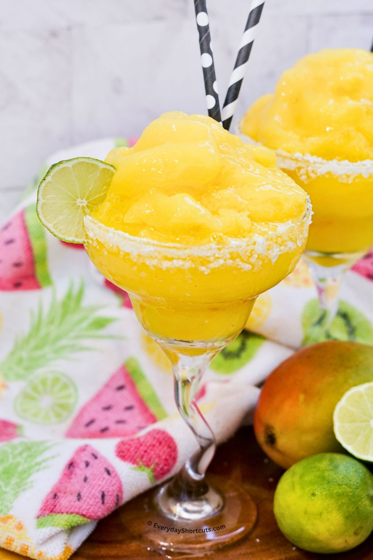 mango margarita frozen in a glass with a salted rim and lime garnish