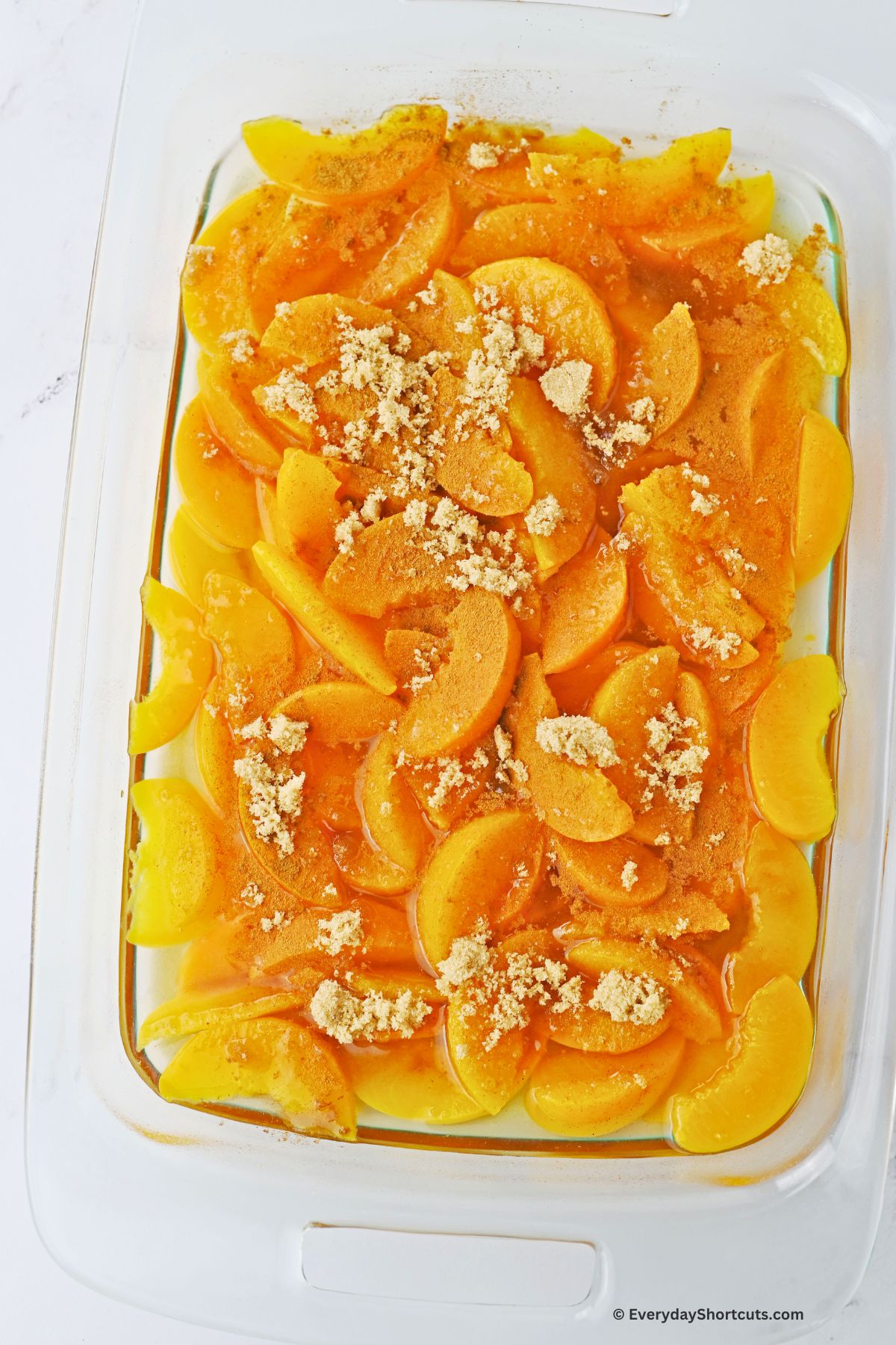 brown sugar on top of peaches in a baking dish