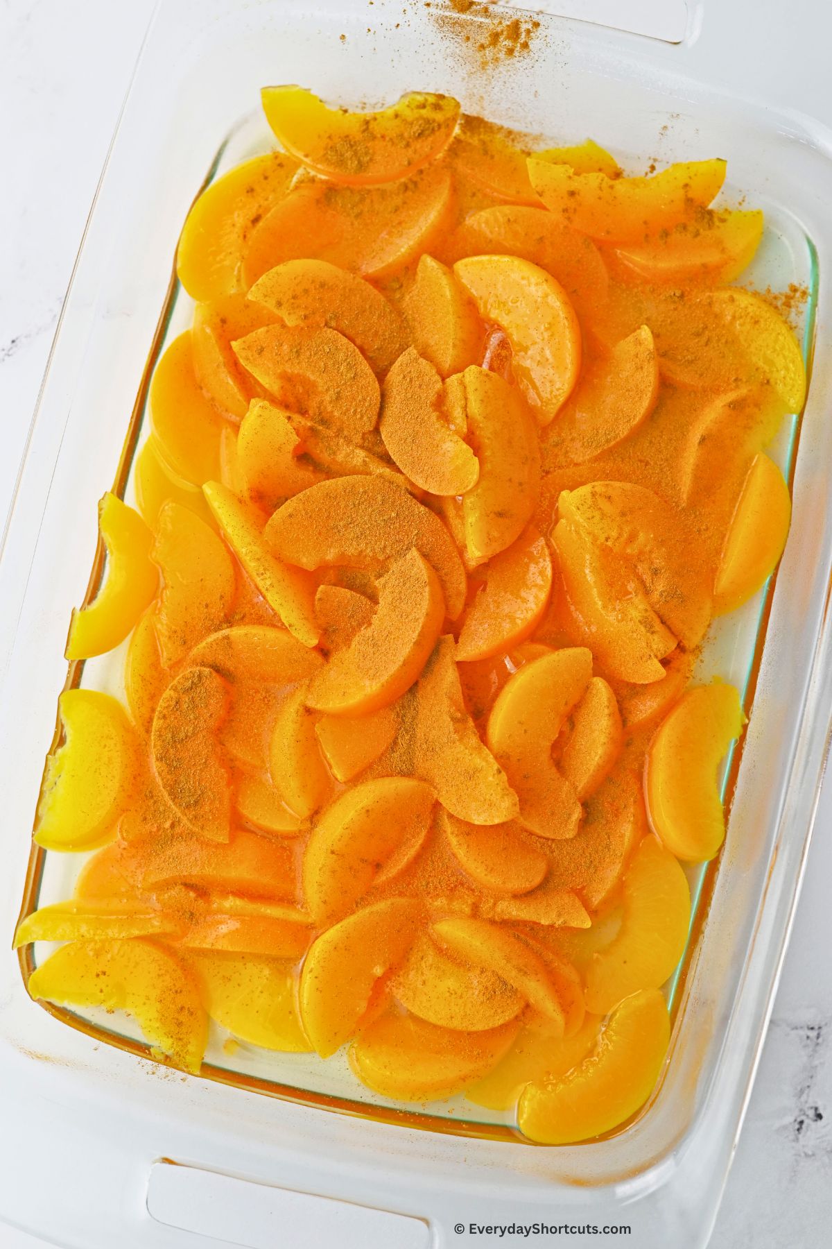 peach slices with cinnamon on top in a baking dish