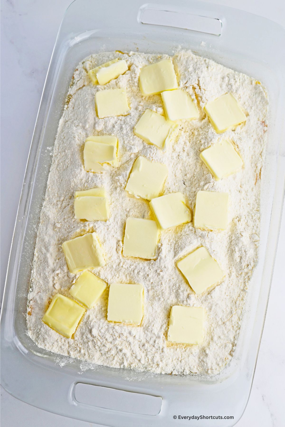 butter slices on top of cake mix in a baking dish