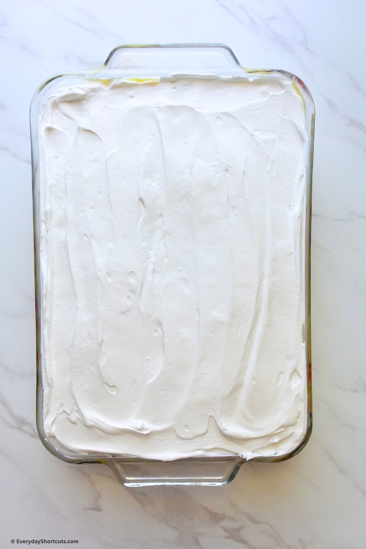 whipped topping on creamy pudding layer in baking dish