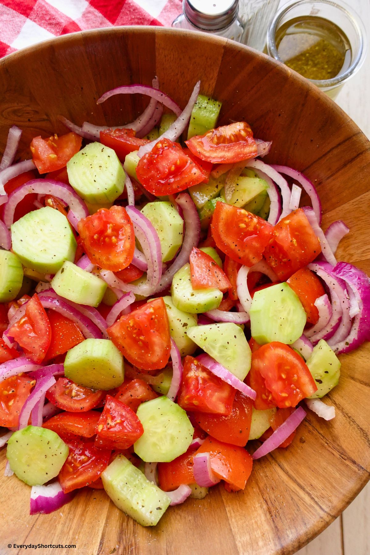 cucumber tomato salad in a bowl tossed in dressing