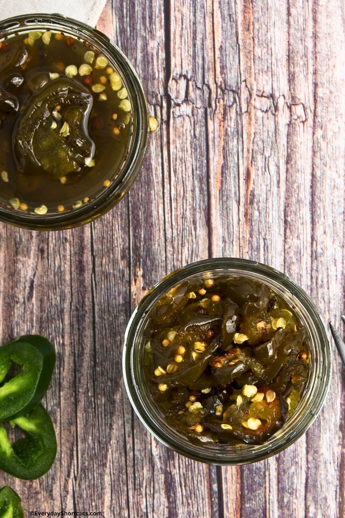 sliced jalapenos in a jar with syrup and seasonings