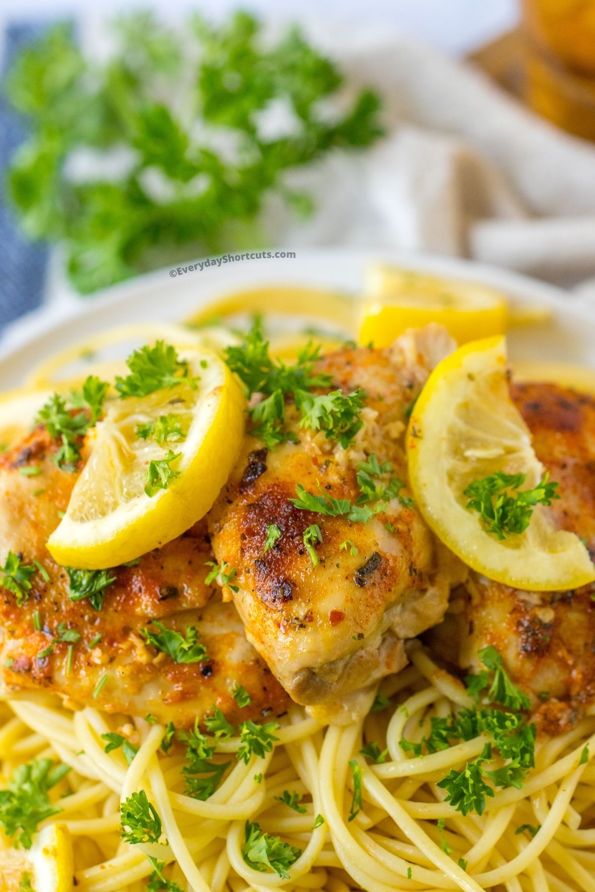 Garlic Butter Chicken Thighs on a plate with lemon garnish