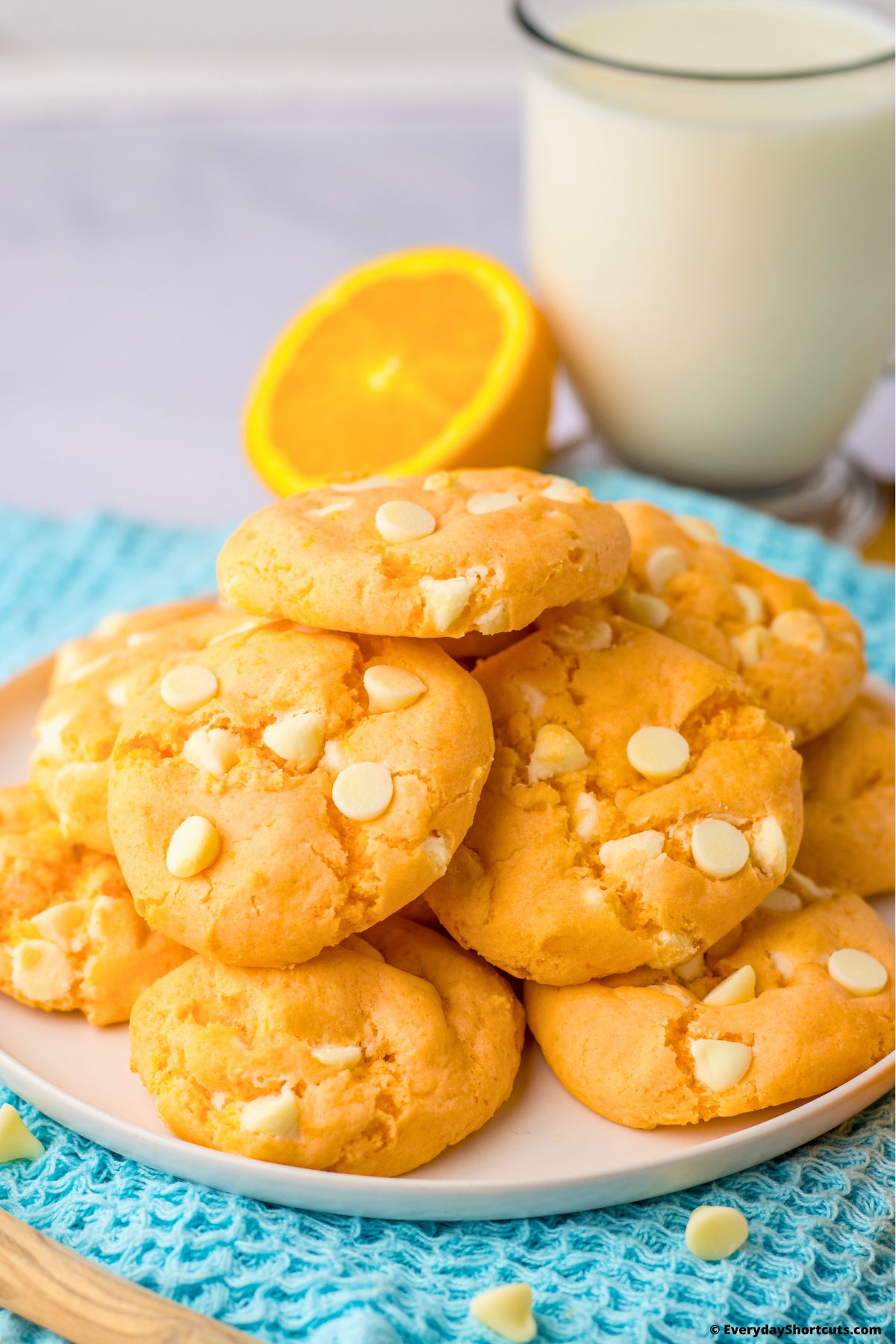 creamsicle cookies on a plate with a glass of milk on the side