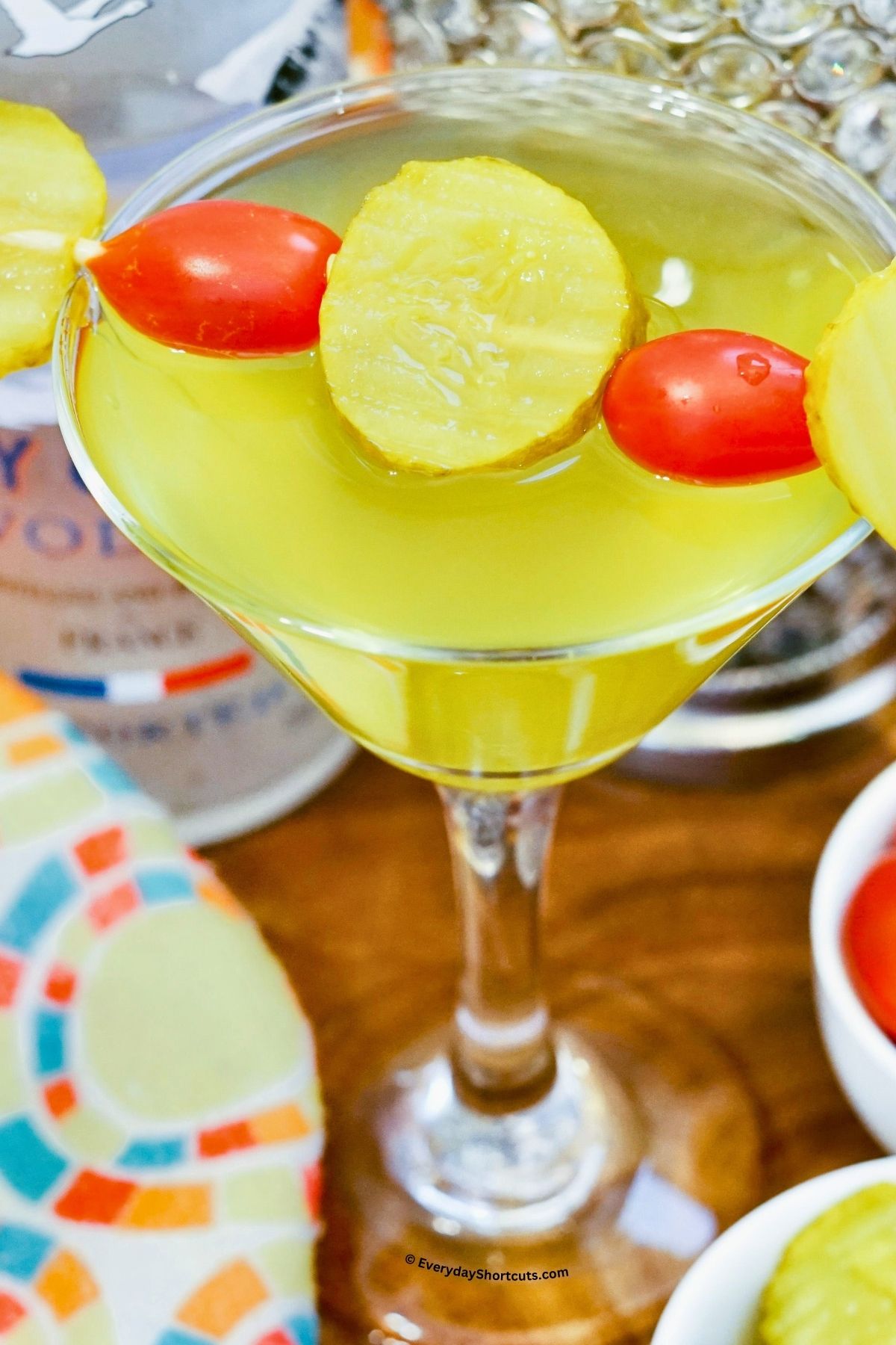pickle martini garnished with dill pickle chips and cherry tomatoes