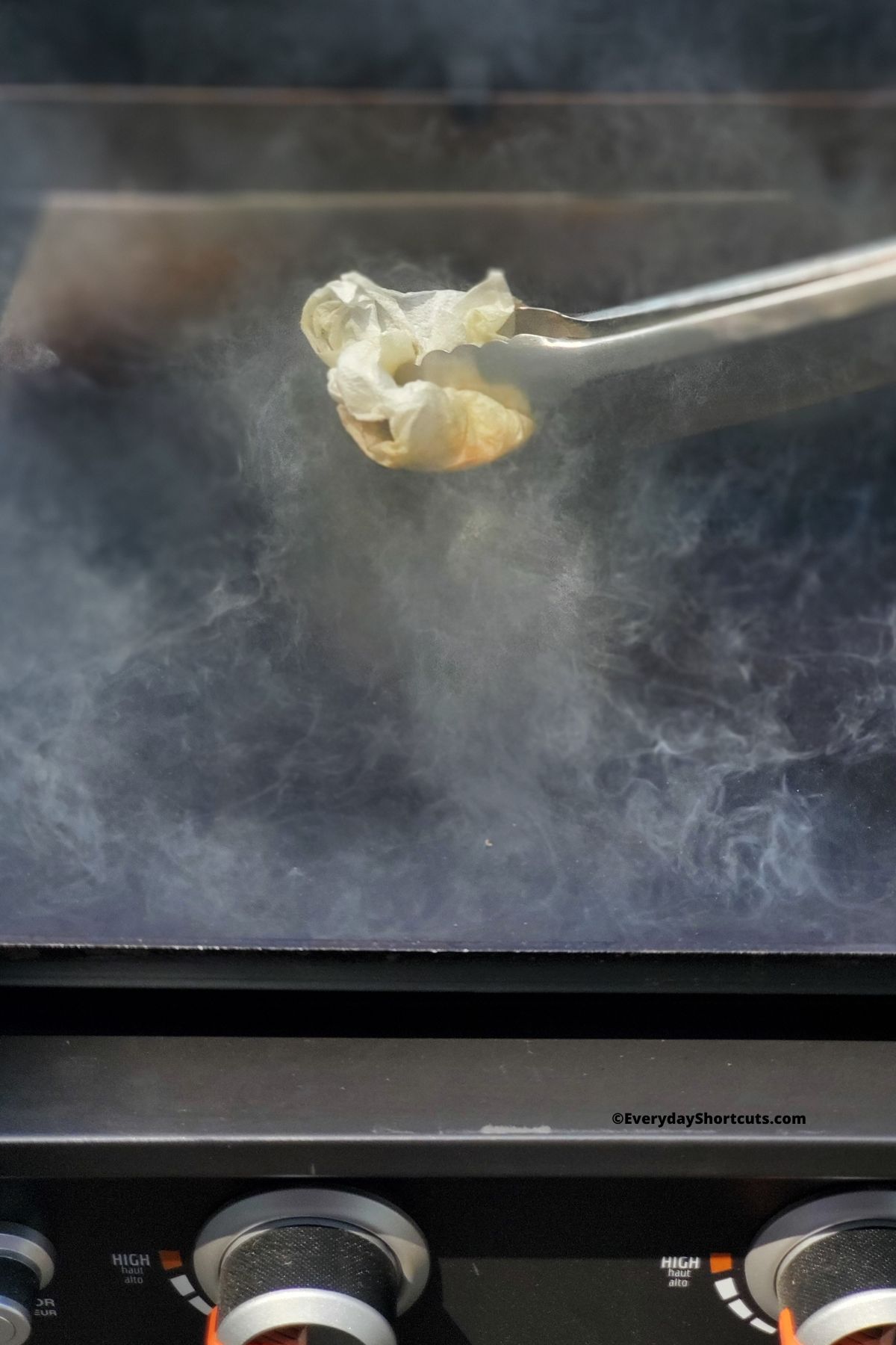 brushing oil on griddle using a paper towel dipped in oil and tongs