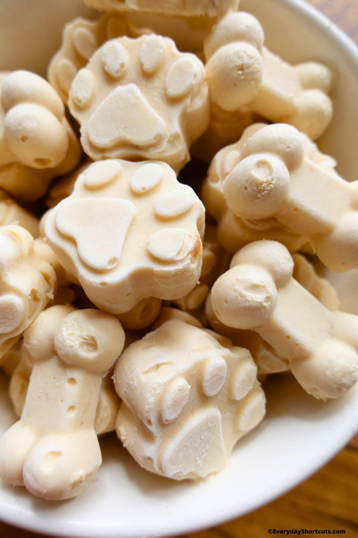 paw and bone shaped frozen dog treats in a bowl