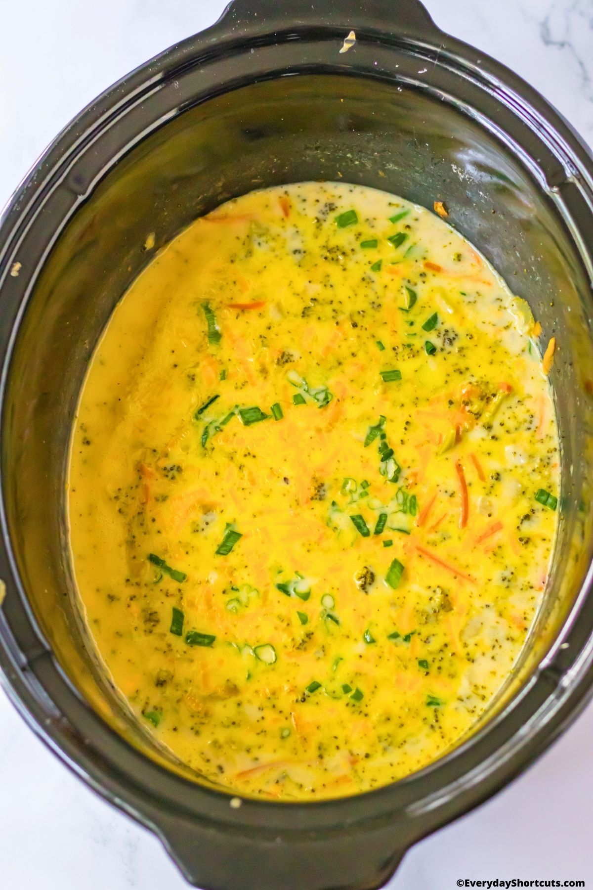 melted cheese in crockpot with broccoli and carrots