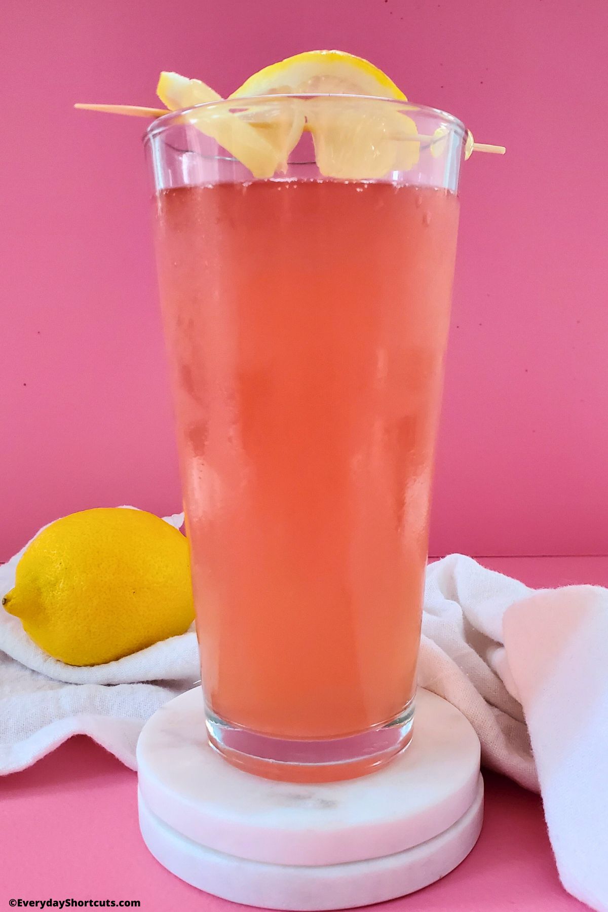 pink porch crawler drink in a glass garnished with lemon