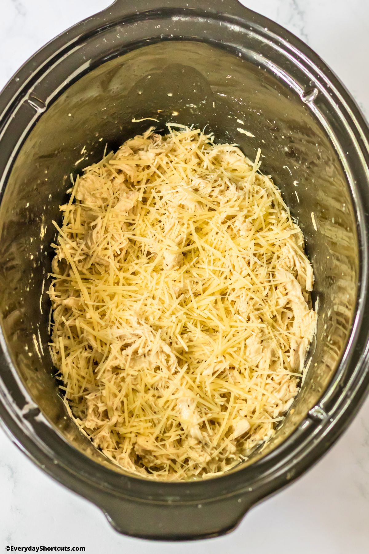 parmesan cheese on top of chicken in a crock pot