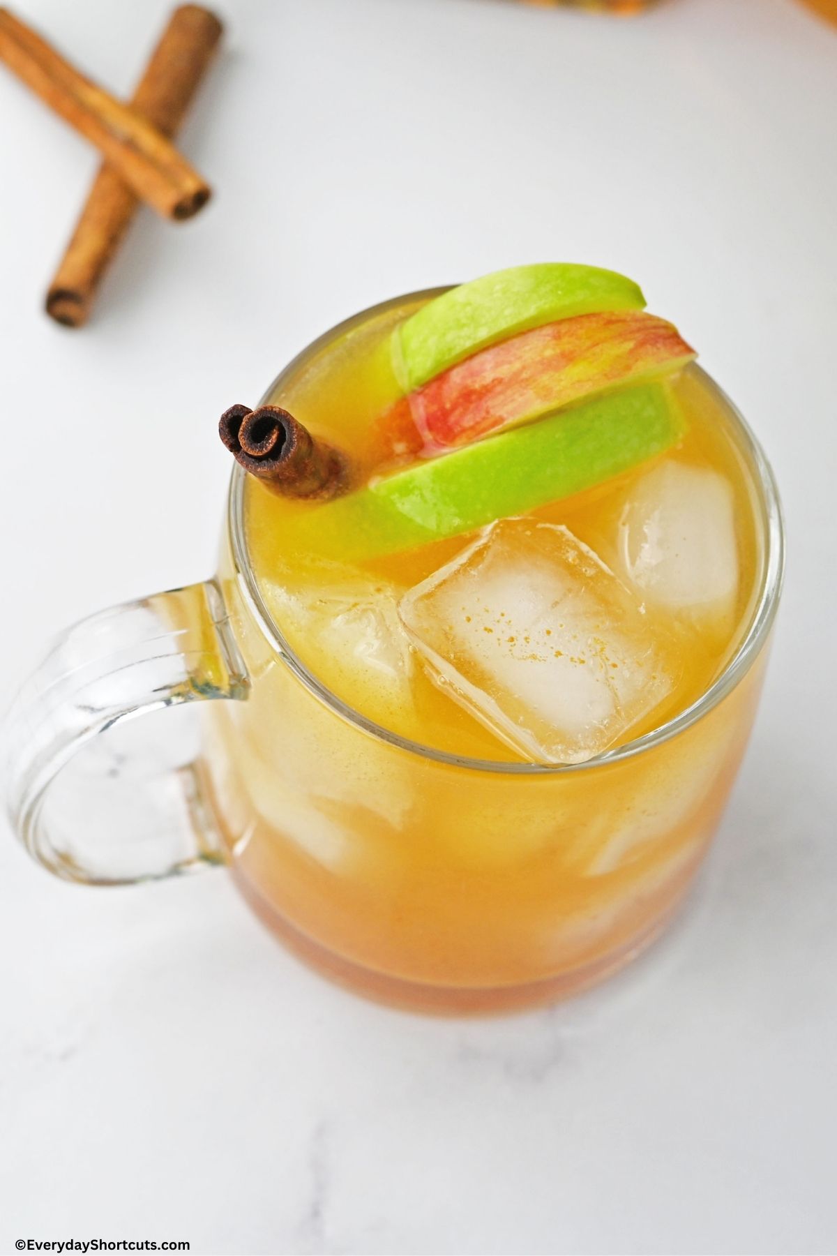 cider bourbon cocktail in a glass with apples and a cinnamon stick