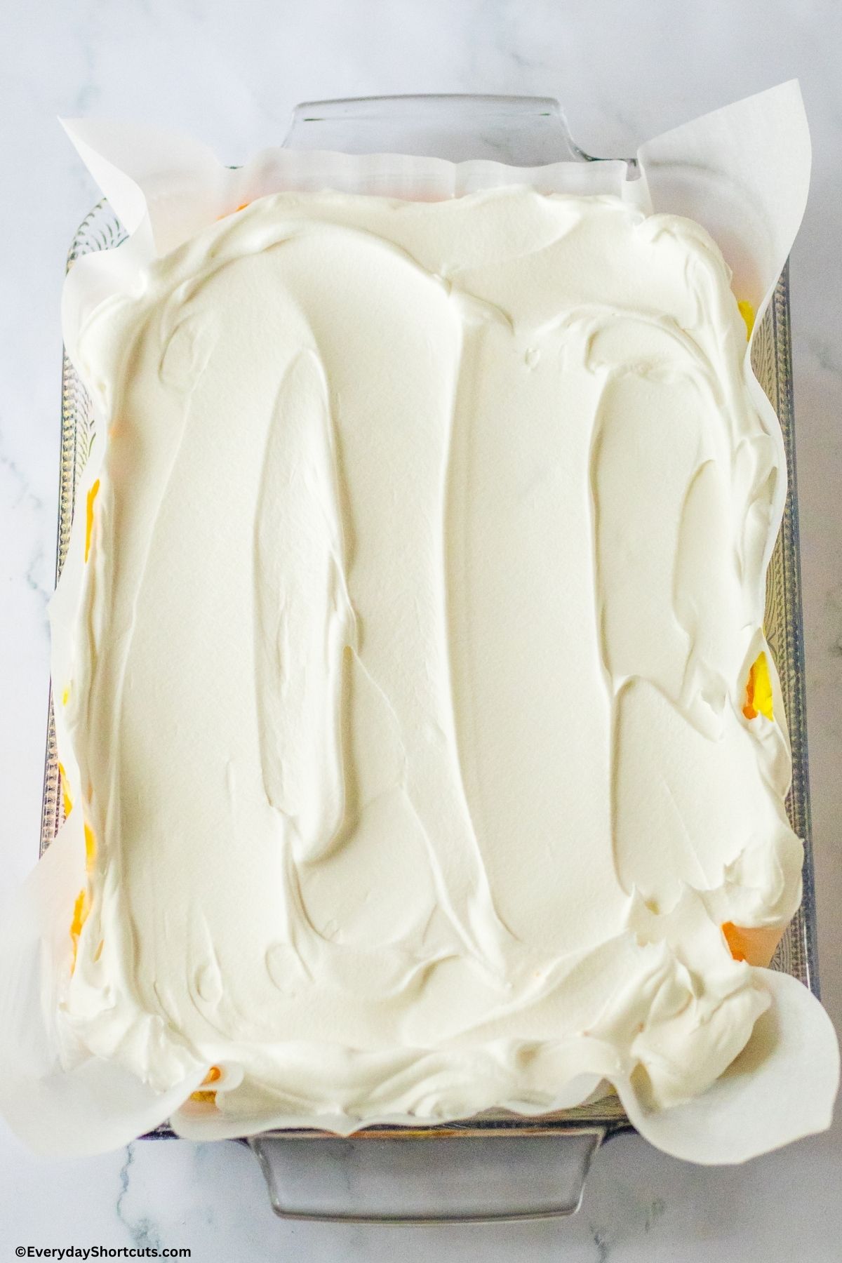 whipped topping on top of layered lush dessert in a baking dish