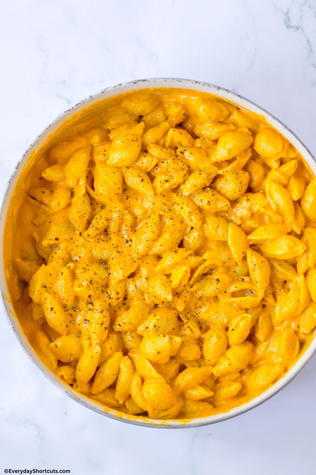 pasta mixed with cheese sauce in a pan