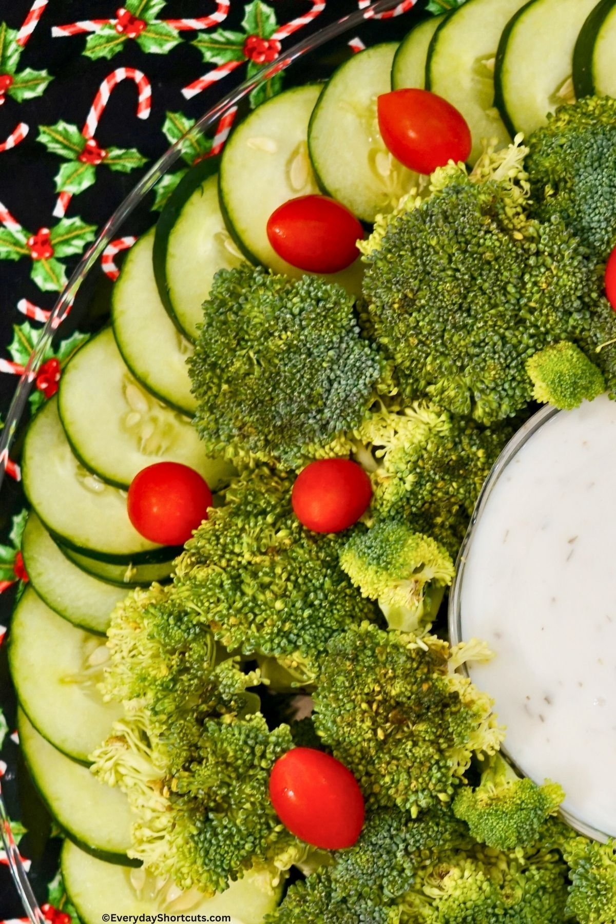 cucumbers broccoli and tomatoes in a circular pattern on a platter