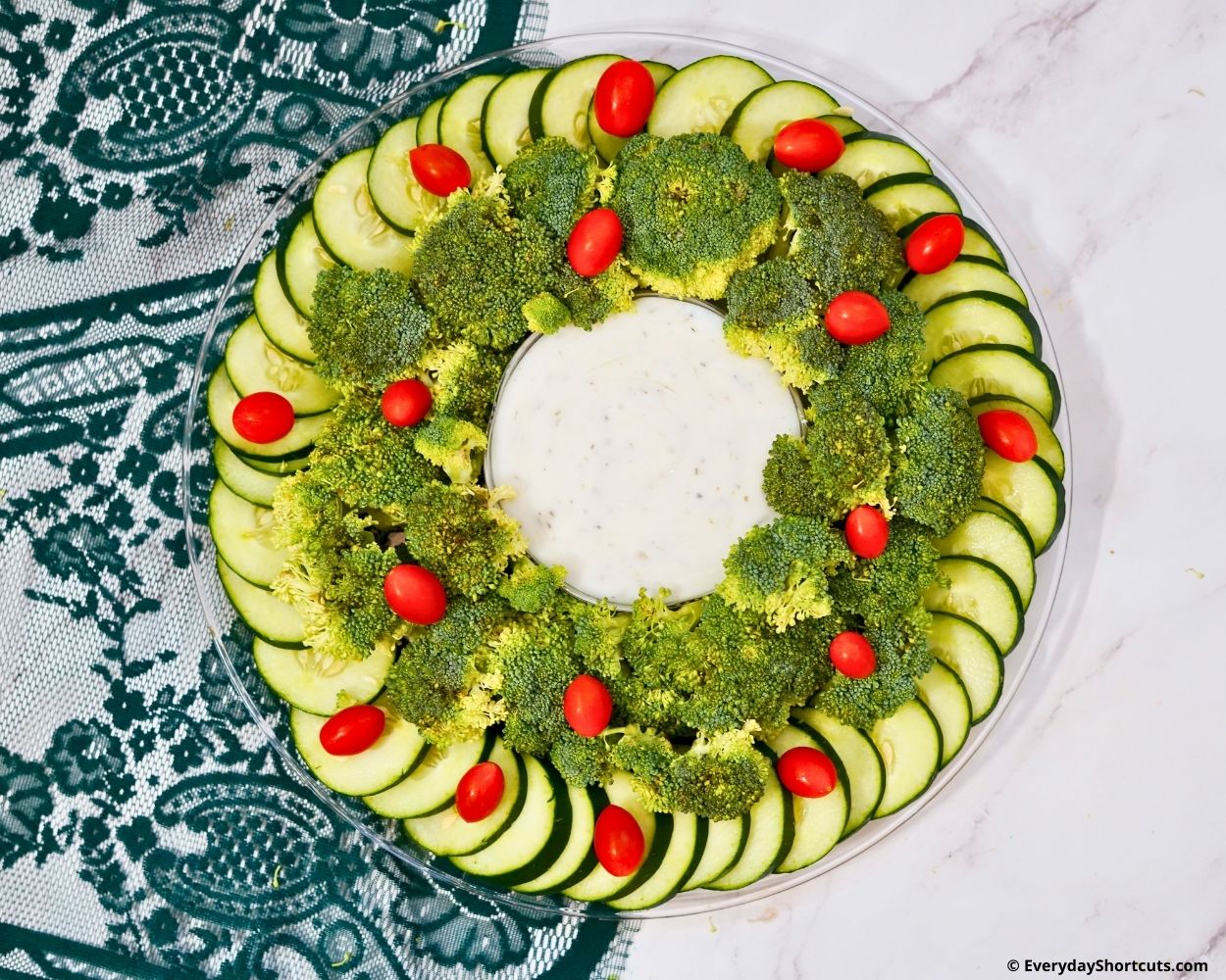 broccoli cucumber and tomatoes in a circular pattern on tray