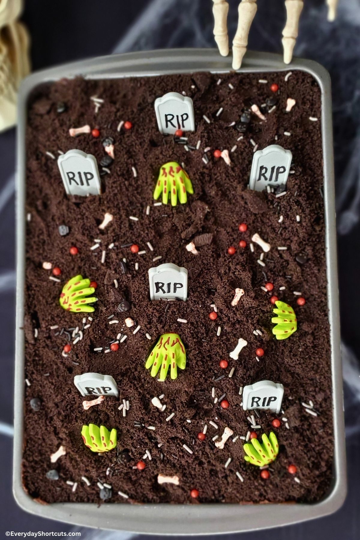 Halloween cake with tombstones and zombie hands