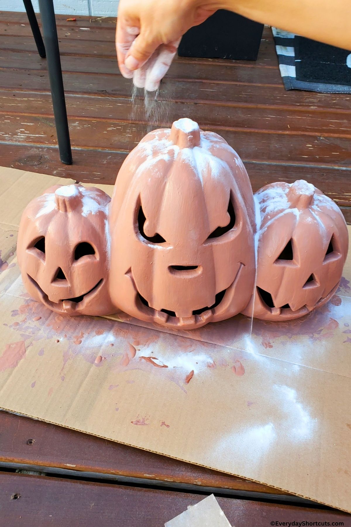 sprinkling baking soda over top of painted pumpkins