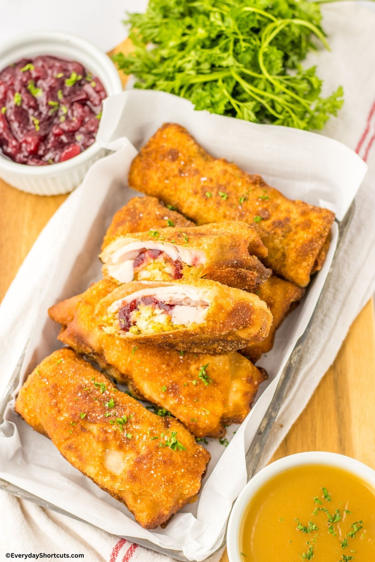 Thanksgiving egg rolls on a platter with cranberry sauce and gravy