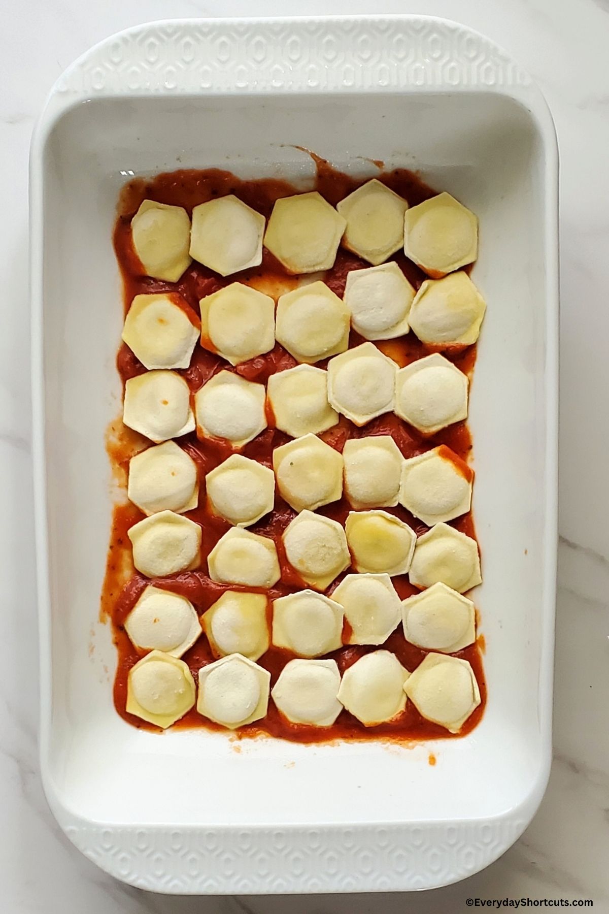 cheese pasta on top of marinara sauce in dish