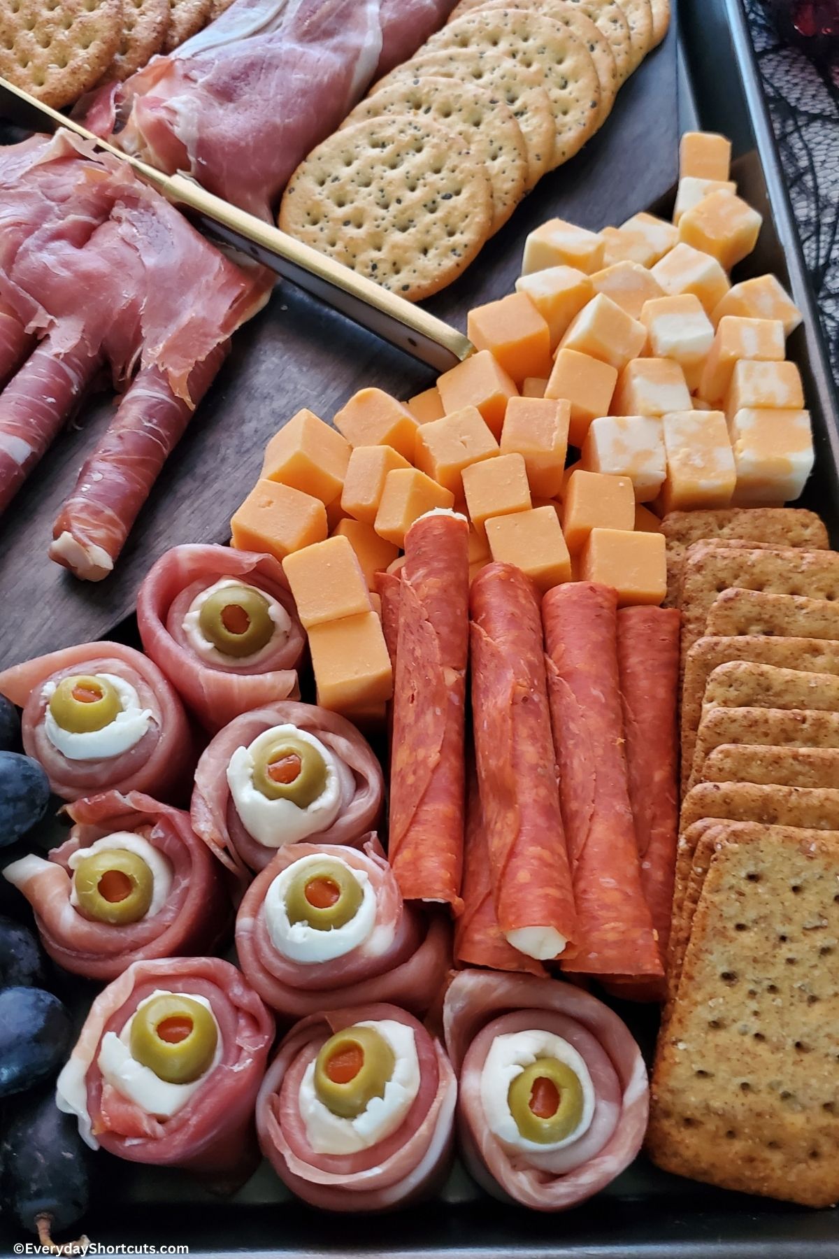 prosciutto eyeballs and cheeses on a charcuterie board