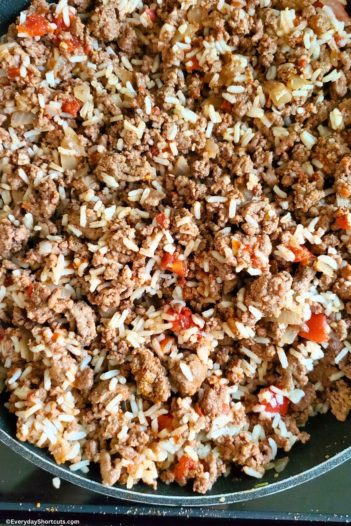 meat mixture with tomatoes and rice in a pan