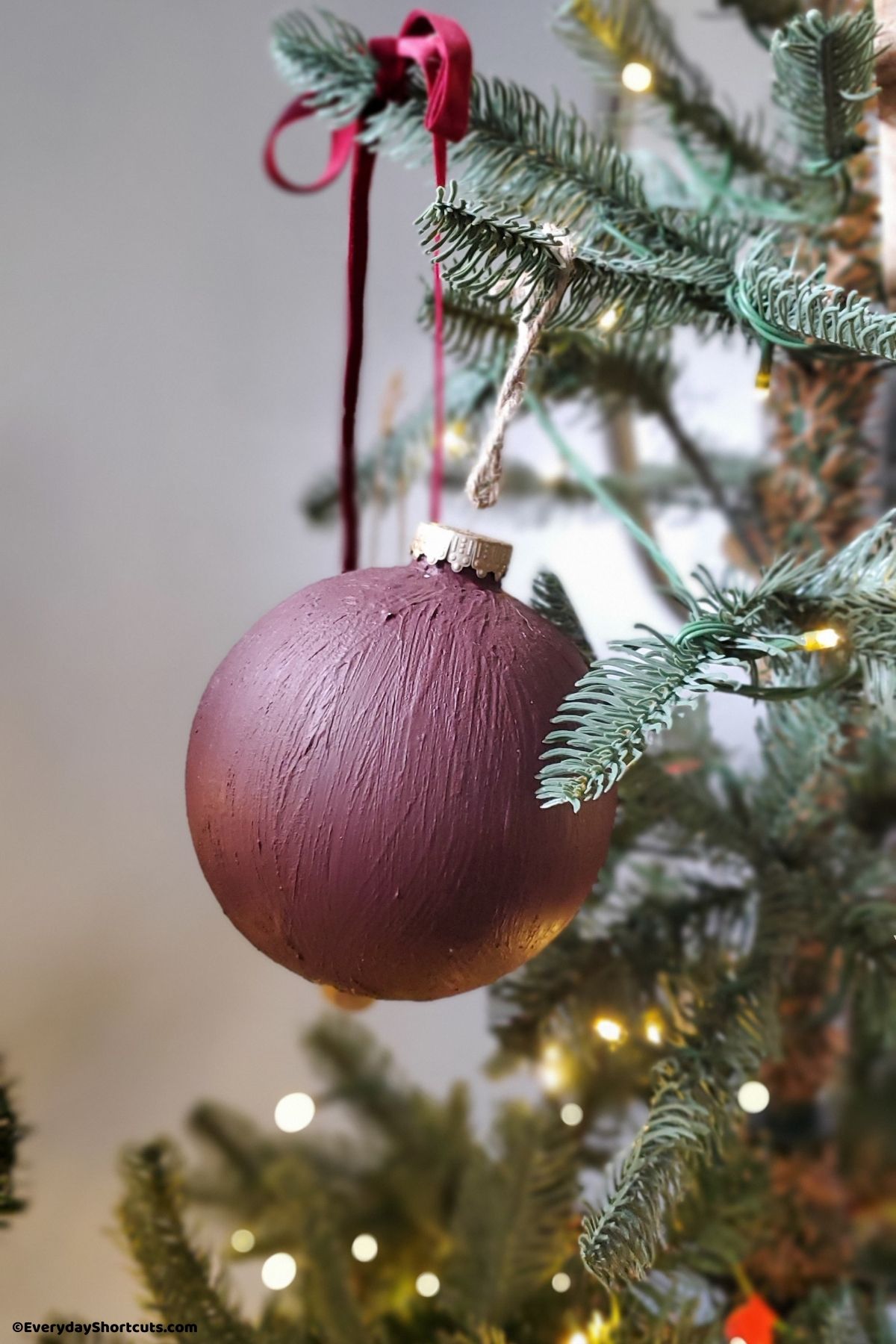 burgundy painted ornament on a Christmas tree