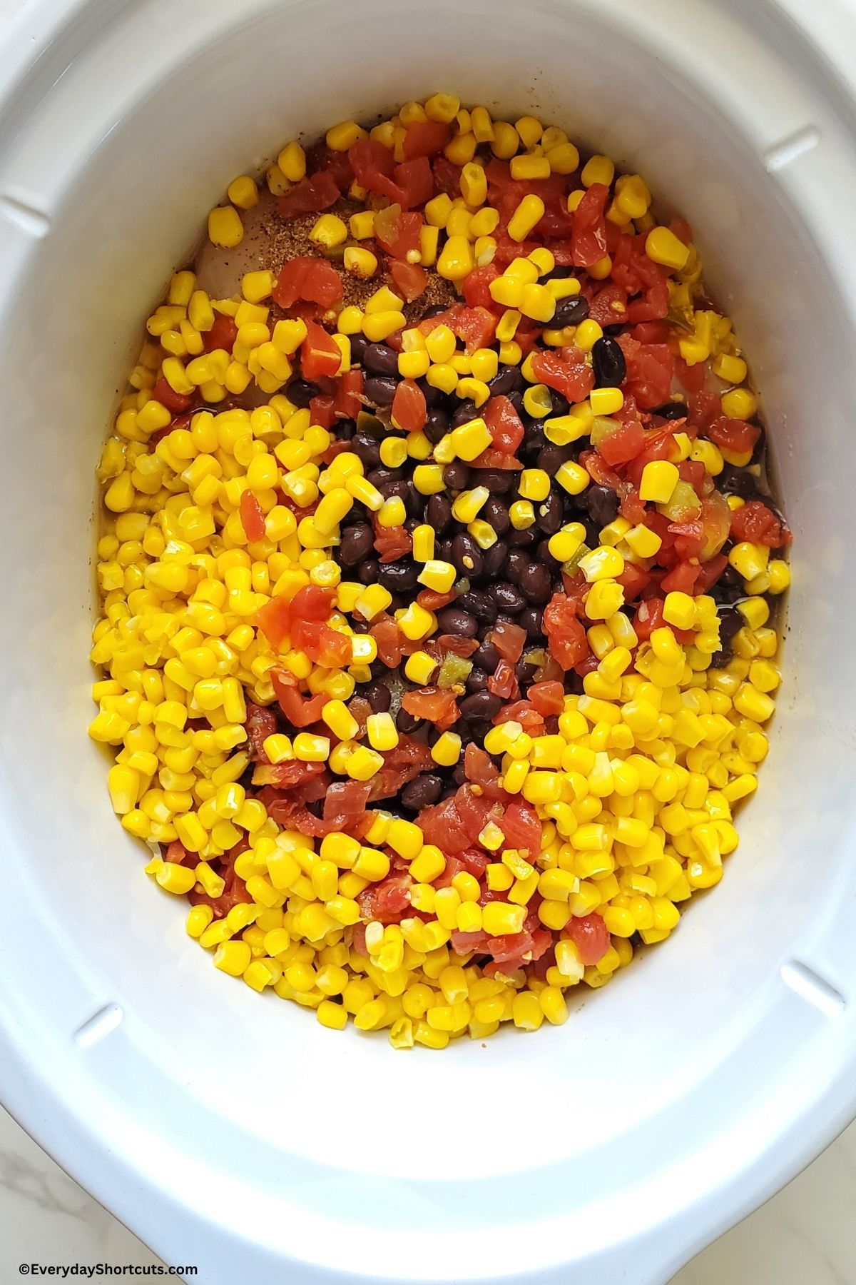 chicken corn beans tomatoes and seasonings in a slow cooker
