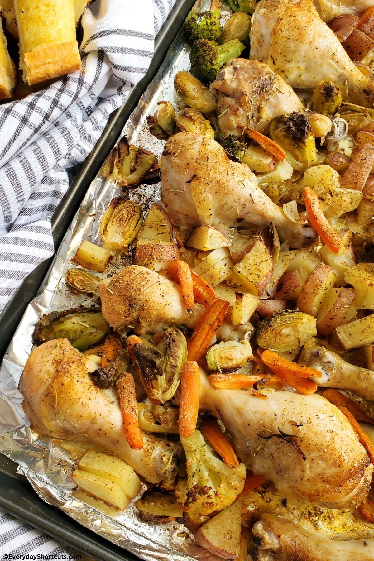 chicken legs brussels sprouts carrots potatoes broccoli on a pan
