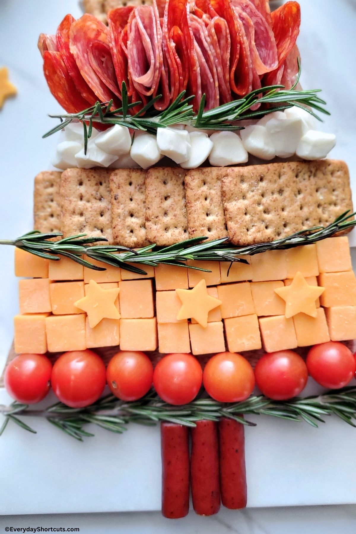 crackers and cheeses on a holiday tree board