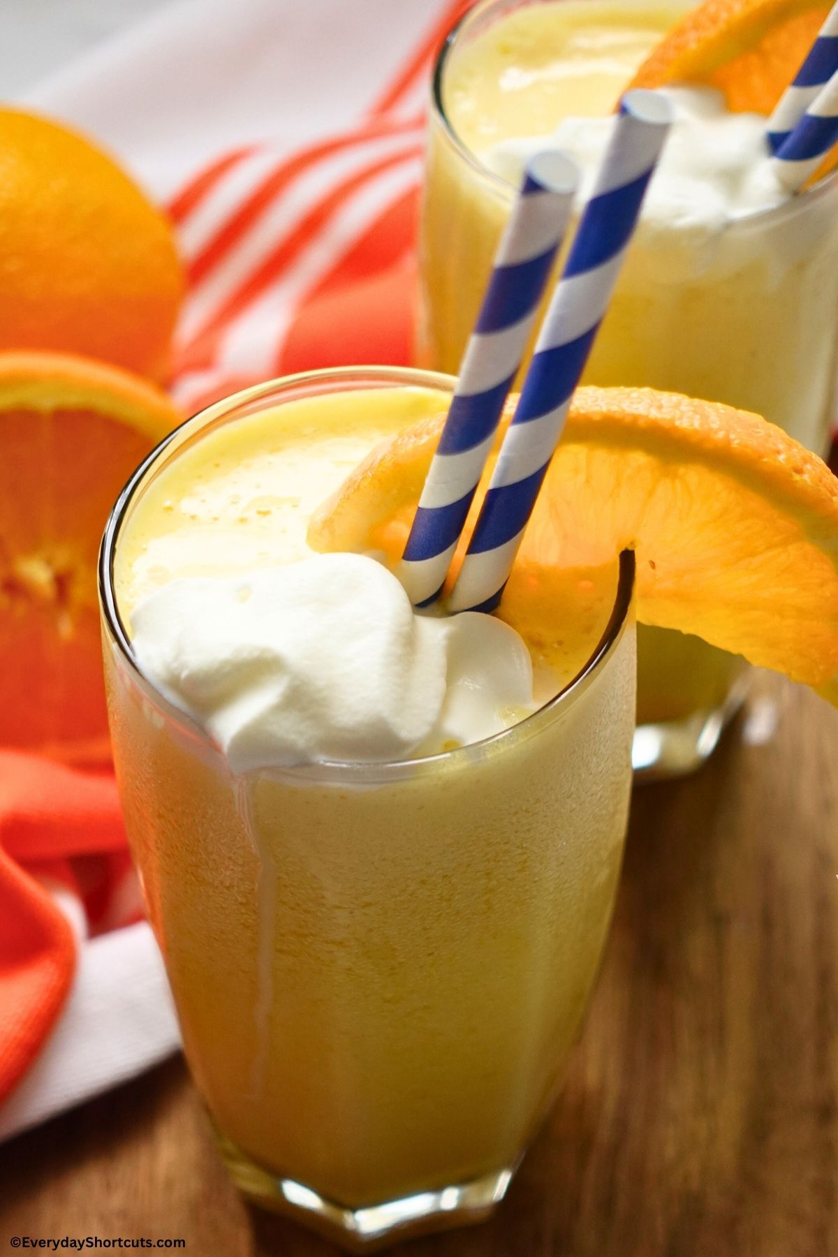 creamy Orange Julius drink in a glass with a orange slice and straw