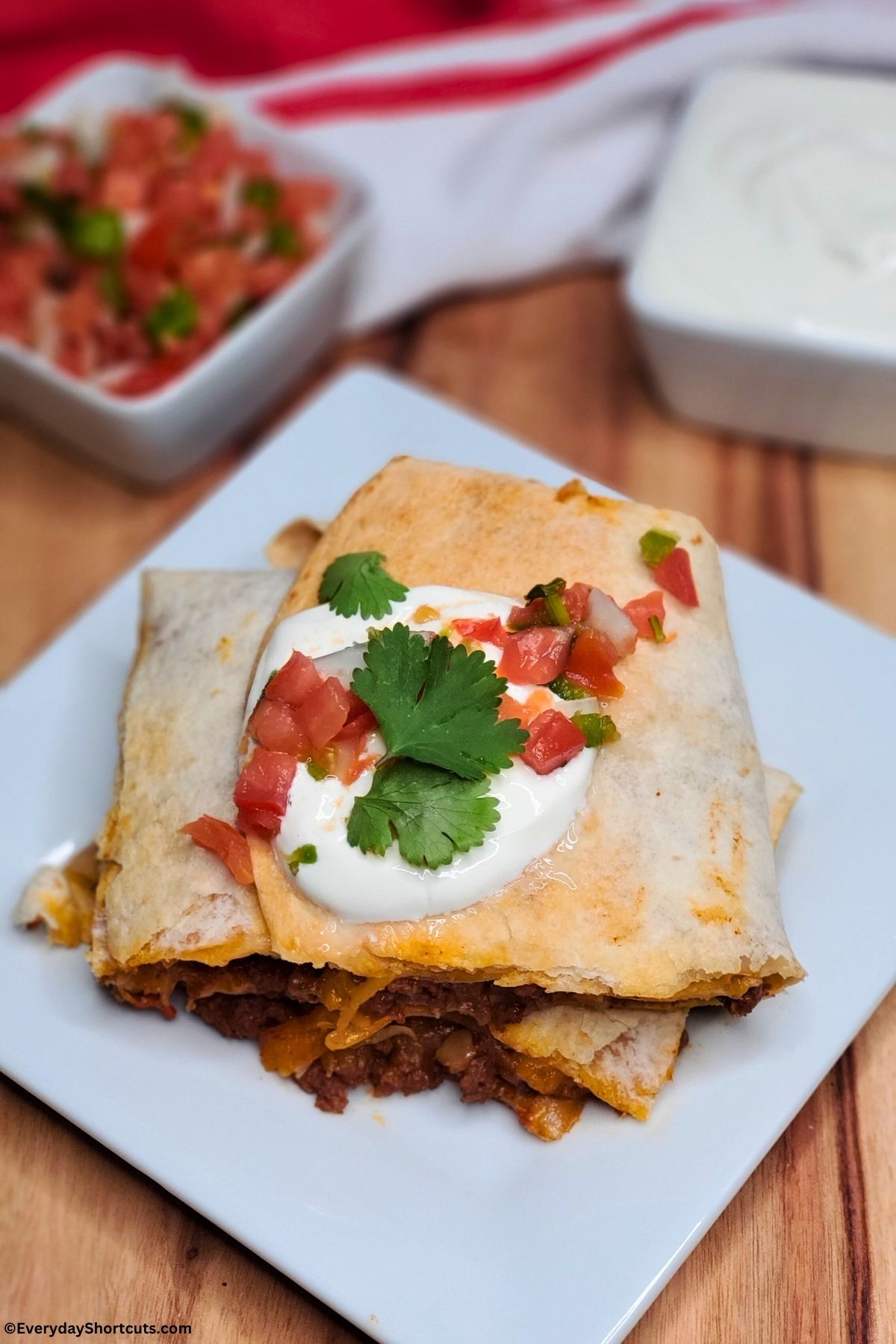 sheet pan tacos on a plate with sour cream and pico de gallo