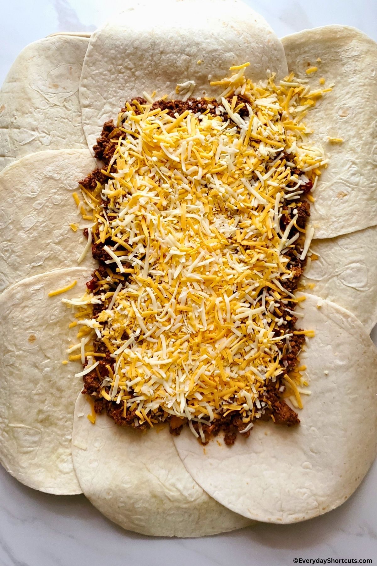 seasoned ground beef and cheese on top of flour tortillas