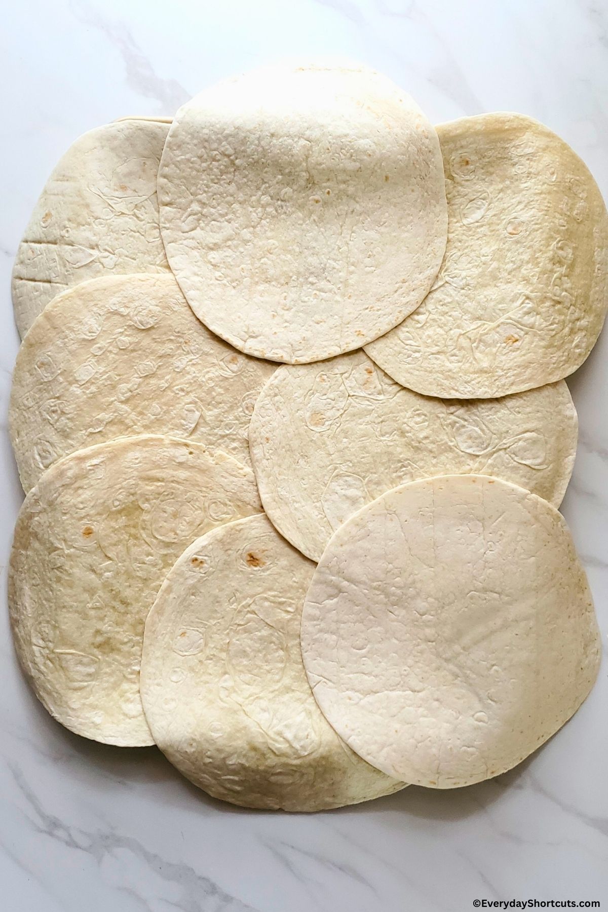 flour tortillas overlapping on a baking sheet