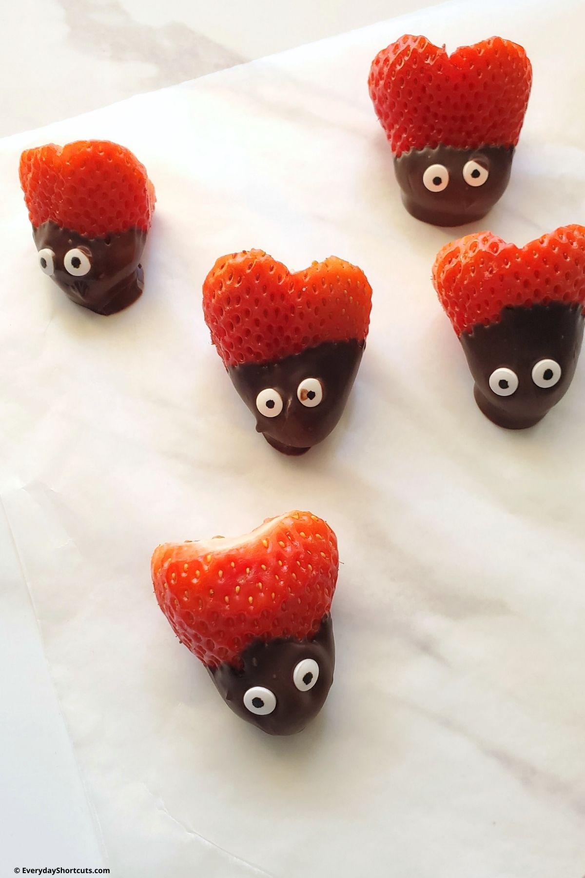 strawberries with chocolate dipped on one end and candy eyes