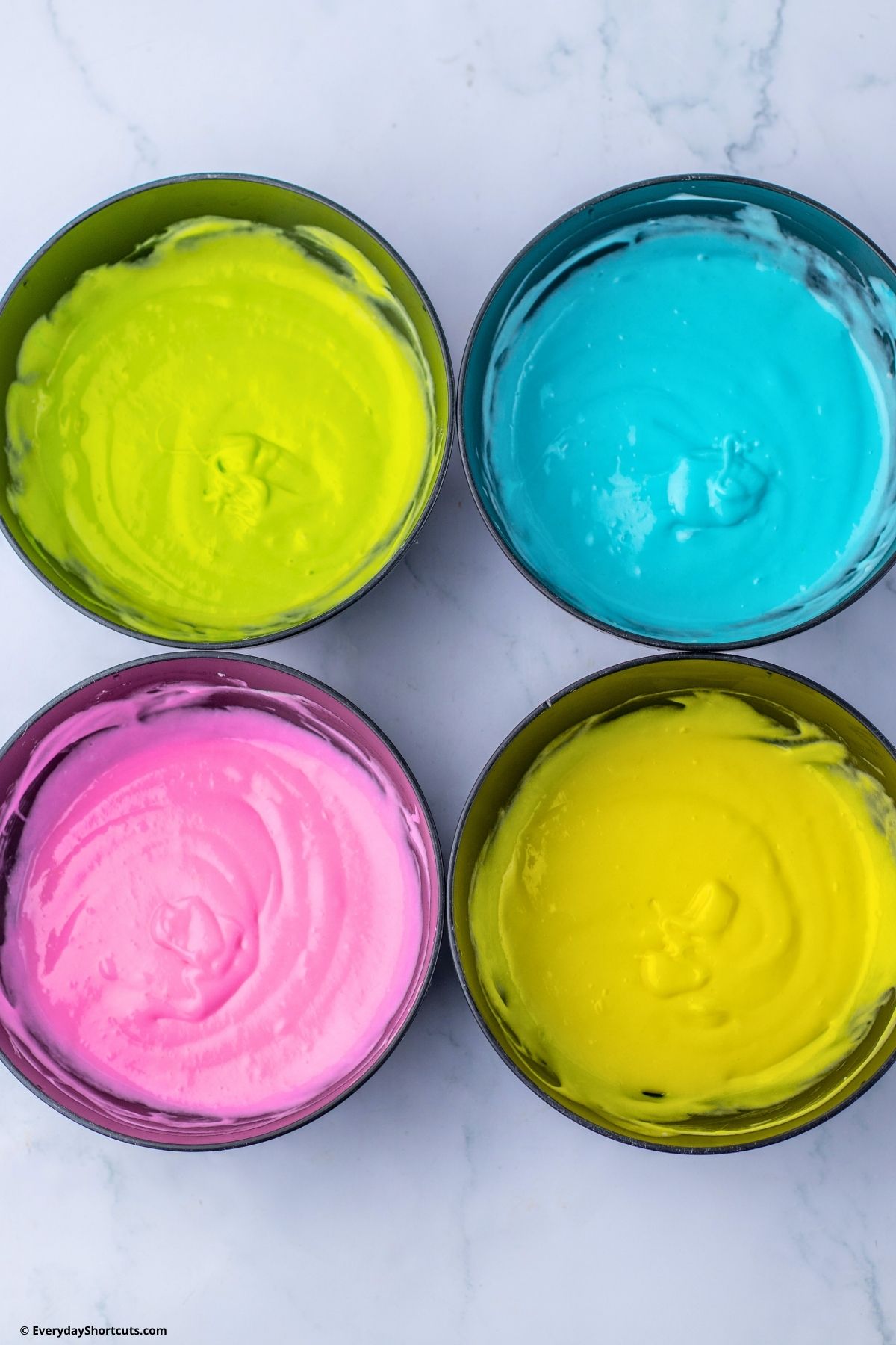 pastel colored cake batter in bowls
