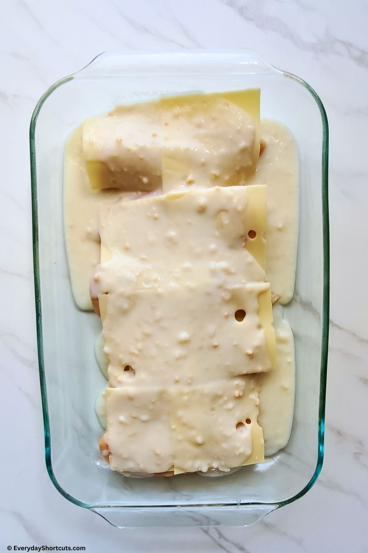 cream of chicken soup mixture on top of chicken and cheese