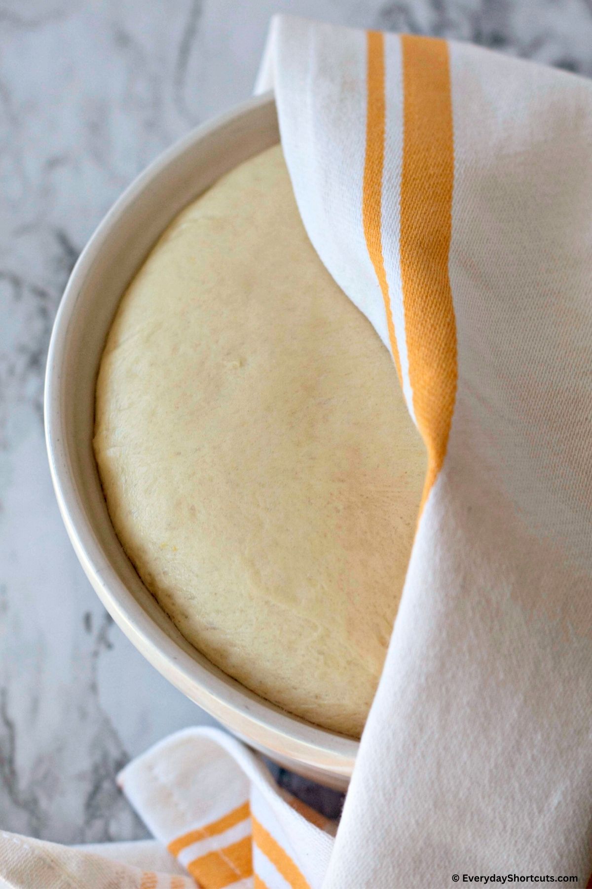 English muffins rising dough in bowl