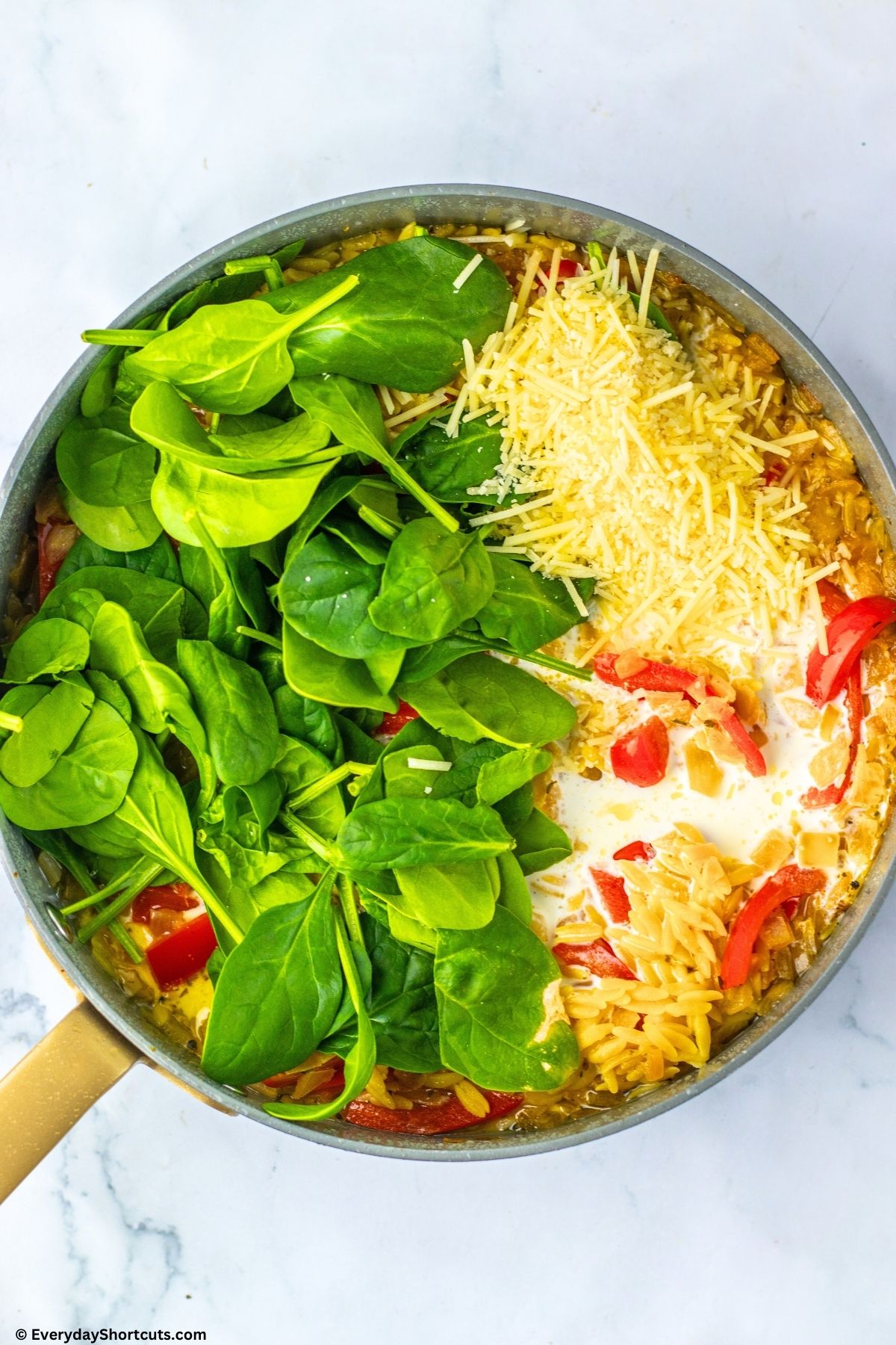 orzo with spinach and parmesan cheese in pan